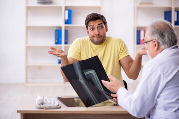 Obraz premium Young male patient visiting old male doctor