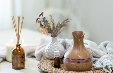 Spa composition with aroma oil diffuser lamp on a blurred background.