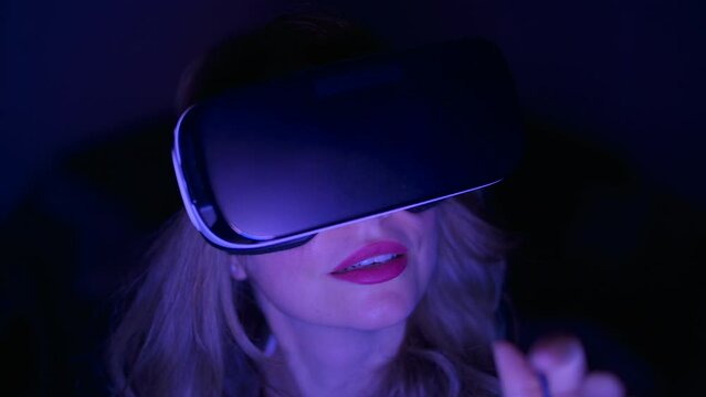 Woman in VR helmet playing at home