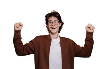 Amazed German teenager in glasses, brown jacket and white t-shirt rises clenched fists in winner expression toothy smiles looks at camera standing against transparent background. Mockup, success.