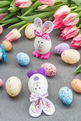Easter flat lay with cute rabbits, eggs and tulips. Traditional decor, festive greeting card