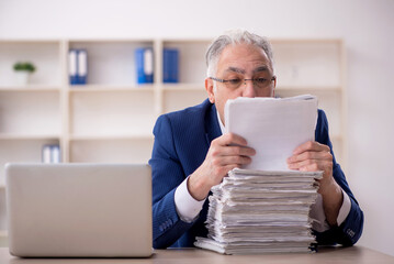 Old male employee unhappy with excessive work in the office