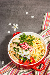 Asian noodles with chicken, vegetables, and herbs in a red bowl. Traditional Japanese soup