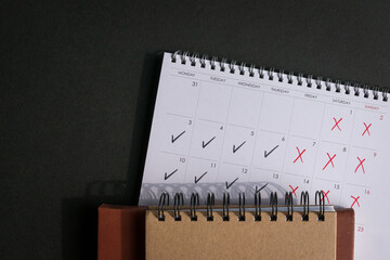 Calendar with ticks and crosses, depicting four day work week concept. Top view. Copy space. - obrazy, fototapety, plakaty