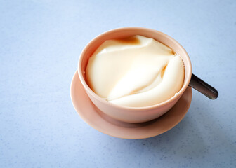 Tau foo fah (Soy bean pudding) in a bowl on top of a table. Copy space.