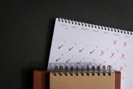 Calendar with ticks and crosses, depicting four day work week concept. Top view. Copy space.