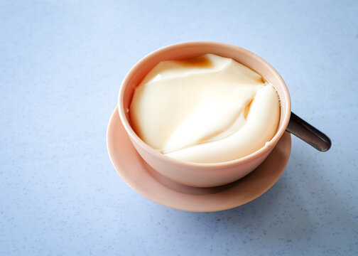 Tau foo fah (Soy bean pudding) in a bowl on top of a table. Copy space.