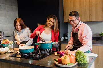 latin friends cooking and eating together in kitchen at home in Mexico Latin America, hispanic people