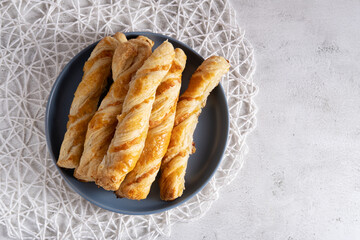 Appetizing cheese sticks on a blue plate on a light background