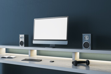 Simple dark blue designer workplace with empty mock up computer screen, loud speakers and other items. 3D Rendering.