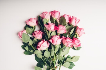 Heap of beautiful fresh pink roses in full bloom on white background. Bouquet of flowers, flat lay. Valentine's day or Mother's day card.