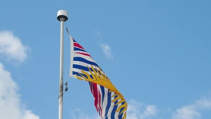 Slow motion shot of a British Columbia flag flying on a sunny day.
