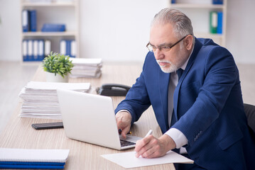 Old male employee working in the office