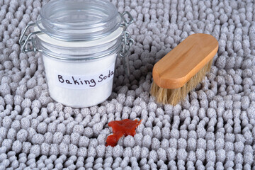 Dirty red stain on gray carpet at home. Using Baking soda cleaning. The concept of organic and...