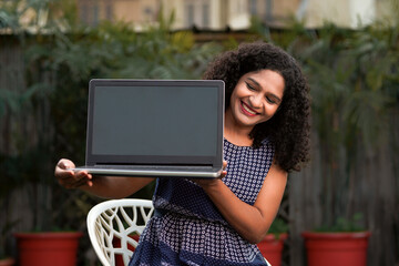 Indian woman showing laptop screen. technology concept.