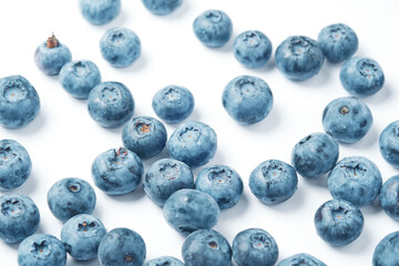 Fresh blueberries scattered on a white background.