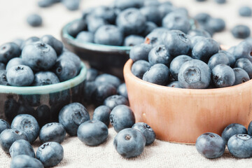 Three ceramic bowls with blueberries and berries scattered around.