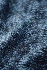 Texture knitted background. Folds of knitted woolen fabric close-up.