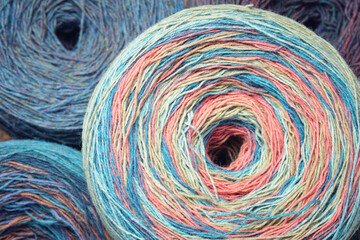 Round skeins of organic multi-coloured lambswool yarn.