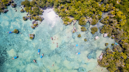 The aerial view of Zanzibar's beaches captures the essence of a tropical paradise with palm trees, umbrellas, white sand, and the sparkling blue waters of the Indian Ocean.
