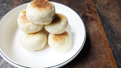 Bakpia, Bakpia Pathok is a typical Yogjakarta food made from a mixture of green beans, cheese and sugar, which is wrapped in flour, then baked. Selective focus image. Served in white plate.