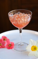 cocktail glass with pink strawberry bubble tea obtained with inverse spherification