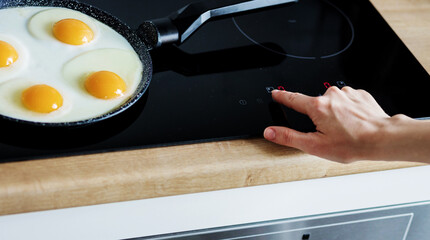woman cooks breakfast on a frying pan