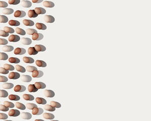 Neutral painted Easter eggs beige brown color gradient on white background with copy space, dark shadow at sunlight. Aesthetic flat lay from Chicken eggs, Easter holiday food minimal pattern
