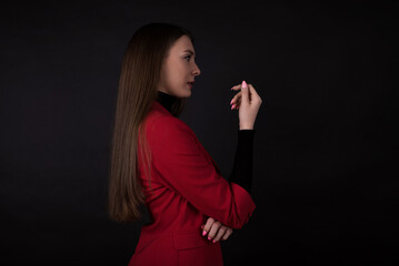 Portrait of a businesswoman in a red suit on a black background.