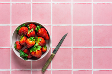 Frische Erdbeeren in einer Schüssel auf einem rosa Fliesen Hintergrund. Draufsicht. 
