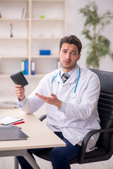 Obraz premium Young male doctor in remuneration concept