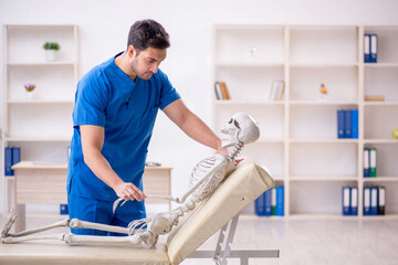 Obraz premium Young male doctor and skeleton patient at the hospital