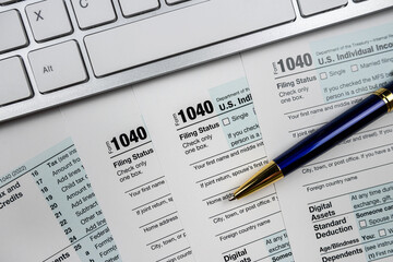 Obraz premium pen with computer keyboard on business finance tax form, office desk