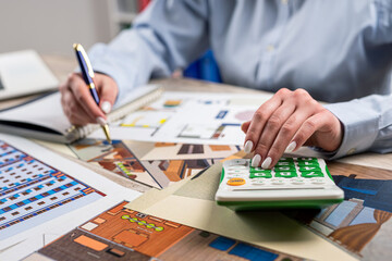 designer woman working blueprint architectural project and tools at office desk