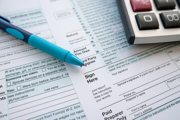 Fototapeta premium 1040 tax form with pen and calculator on office desk