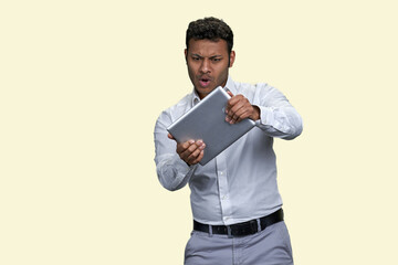 Portrait of a young indian man playing game with tablet. Isolated on white background.