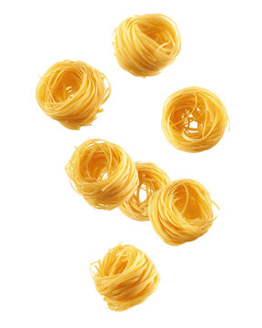 Falling raw Tagliatelle, Tagliolini, Fettuccine, uncooked Italian Pasta, isolated on white background, full depth of field