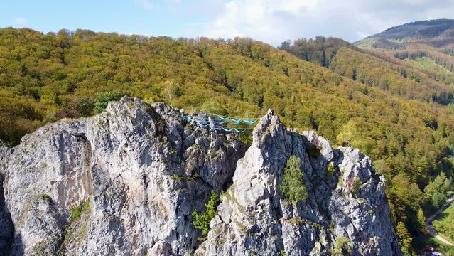 Aerial View of Rock Climbers Relaxing on Blue Hammocks At The Top Of A Mountain,Baia De Fier, Romania