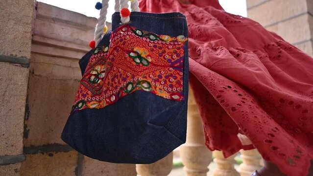 A Pakistani girl showing designer ladies bag from Pakistan handicrafts. No face video.
