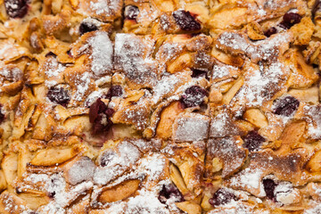 Baked pie with apples and cherries, cut into pieces. Baked pie Charlotte.