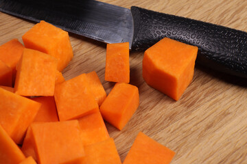 knife and pieces of pumpkin on a cutting board. Cooking baked pumpkin or baby puree
