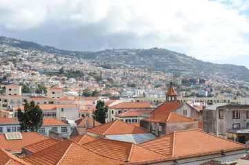 Panoramic view of the old town of Funchal, Madeira island, Portugal with red tile roofs and...