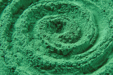 Chlorella or spirulina algae green powder is spinning, rotation. Dietary supplement to improve health. Seaweed superfood. Healthy food background. Vitamins and minerals to diet. Detox. Close up photo - obrazy, fototapety, plakaty