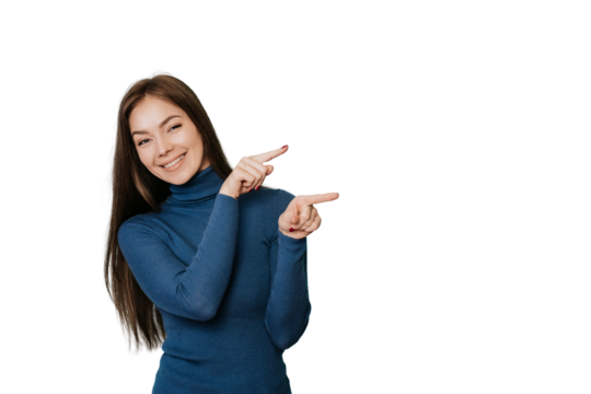 Beautiful European girl with long loose hair in a blue sweater points by  her index fingers to the side, to empty place, on transparent background looks at camera. Mockup, sale, discount, promo.