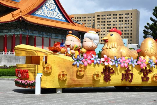 Parade float with grandparents and a golden chicken in Taipei, Taiwan