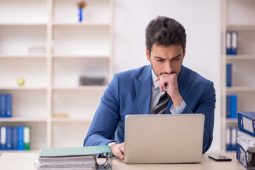 Young male employee and too much work in the office