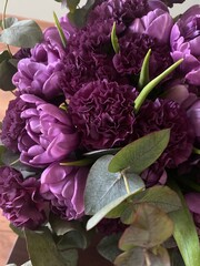 A beautiful bouquet of lilac tulips and fluffy carnations with green eucalyptus