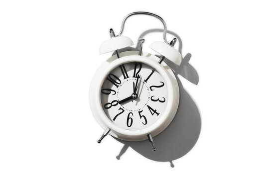 White alarm clock on empty white background, minimalism concept sleep, education, time, banner, top view, copy space