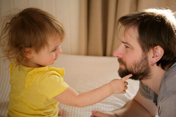 Happy Father with Daughter, Tiny Girl. One Year Baby Smiling, Laughing, Looking up at Daddy. Man Showing Affection to Child. Candid Real Emotion. Beard Dad and Little Kid. Authentic Family Lifestyle.