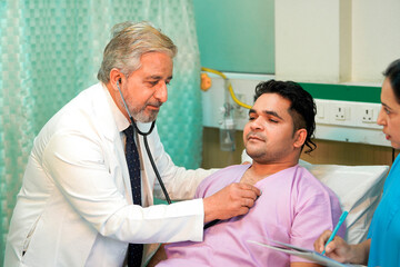 Obraz premium Senior Doctor check up using a stethoscope to patient on bed at hospital.
